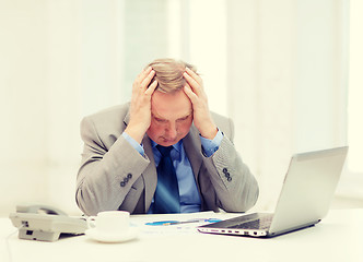 Image showing upset older businessman with laptop and telephone