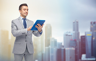 Image showing happy businessman in suit holding tablet pc