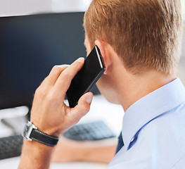 Image showing businessman with smartphone in office