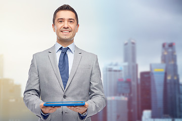 Image showing happy businessman in suit holding tablet pc