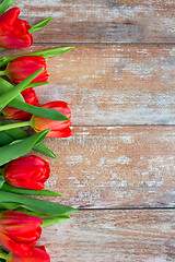 Image showing close up of red tulips on wooden background