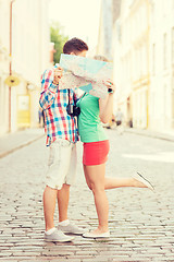 Image showing smiling couple with map and photo camera in city