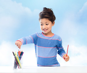 Image showing happy little girl drawing with coloring pencils