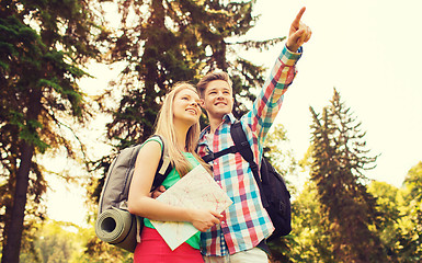 Image showing smiling couple with map and backpack in nature