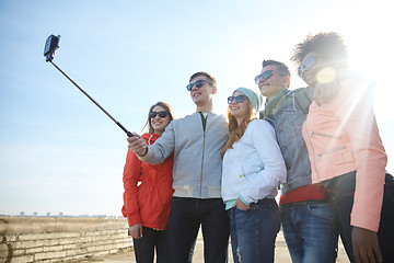 Image showing smiling friends taking selfie with smartphone