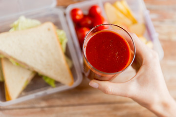 Image showing close up of woman hand holding tomato juice glass