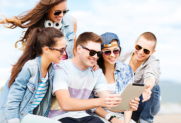 Image showing group of teenagers looking at tablet pc