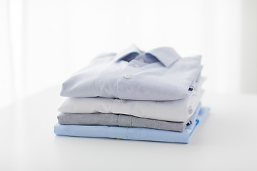 Image showing close up of ironed and folded shirts on table