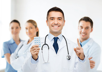 Image showing smiling male doctor in white coat with tablets