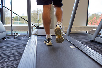 Image showing close up of man legs walking on treadmill in gym
