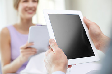 Image showing close up of couple with tablet pc at restaurant