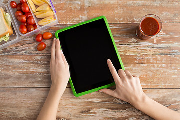 Image showing close up of woman with tablet pc food on table