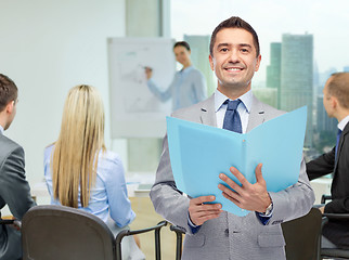 Image showing happy businessman with open folder