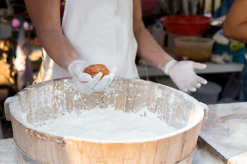 Image showing close up of cook hands with meatball and flour