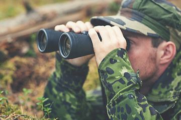 Image showing young soldier or hunter with binocular in forest