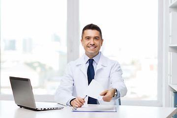 Image showing happy doctor with prescription and laptop
