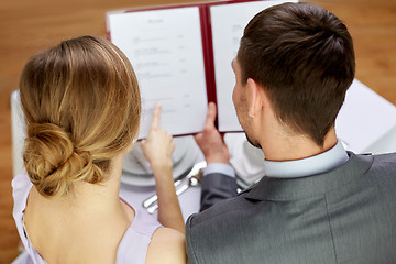 Image showing close up of happy couple with menu at restaurant