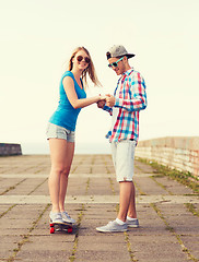 Image showing smiling couple with skateboard outdoors