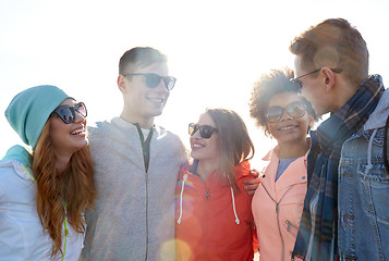 Image showing happy teenage friends in shades talking on street