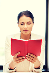 Image showing calm and serious woman with book