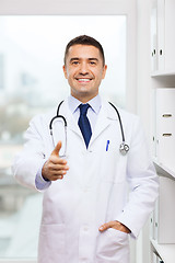 Image showing smiling doctor making handshake at medical office