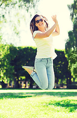 Image showing smiling young woman with sunglasses in park