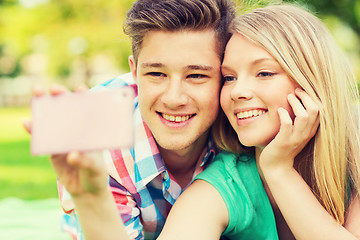 Image showing smiling couple making selfie in park