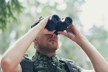 Image showing young soldier or hunter with binocular in forest