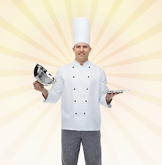 Image showing happy male chef cook opening cloche