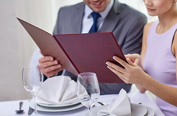 Image showing close up of happy couple with menu at restaurant