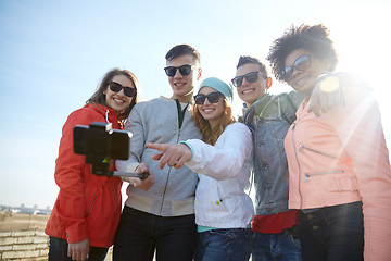 Image showing smiling friends taking selfie with smartphone