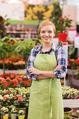 Image showing happy woman with flowers in greenhouse