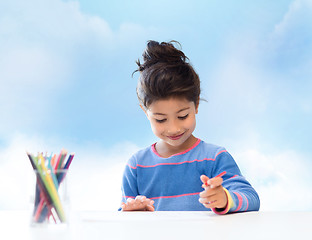 Image showing happy little girl drawing with coloring pencils