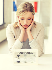 Image showing pensive businesswoman with sand glass