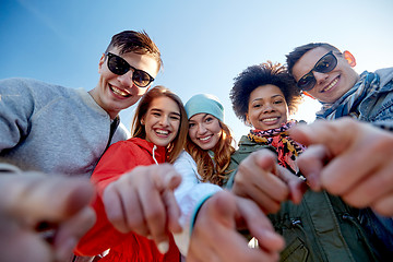 Image showing happy teenage friends pointing fingers on street