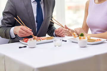 Image showing close up of couple eating sushi at restaurant