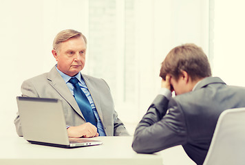 Image showing older man and young man having argument in office