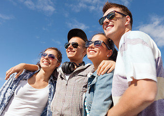 Image showing smiling teenagers in sunglasses hanging outside