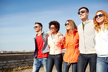 Image showing happy teenage friends walking along city street