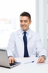 Image showing smiling male doctor with laptop in medical office