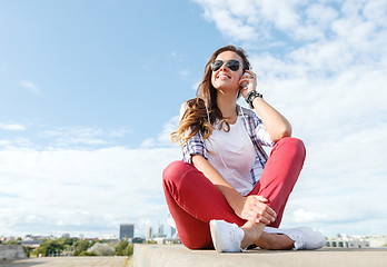 Image showing smiling teenage girl in eyeglasses with headphones