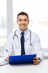Image showing happy doctor with clipboard in office
