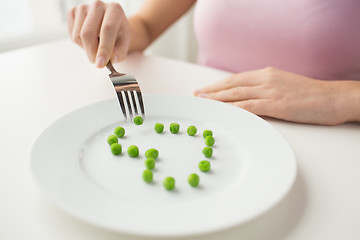 Image showing close up of woman with fork eating peas