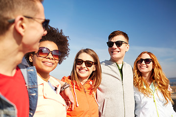 Image showing happy teenage friends in shades talking on street