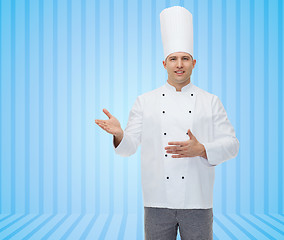 Image showing happy male chef cook inviting