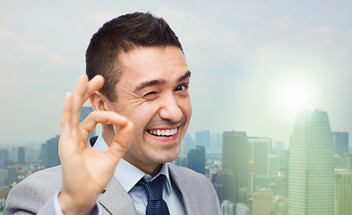 Image showing happy businessman in suit showing ok hand sign