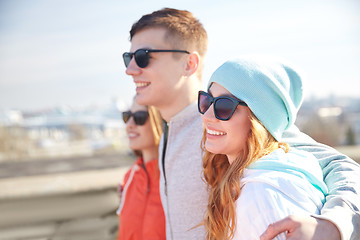 Image showing happy teenage friends in shades hugging on street