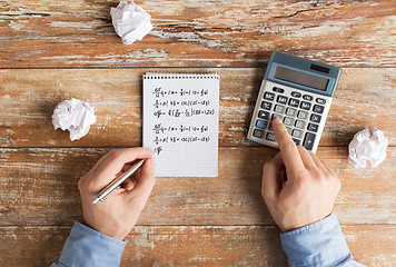 Image showing close up of hands with calculator solving task