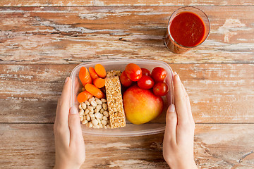 Image showing close up of hands with vegetarian food in box