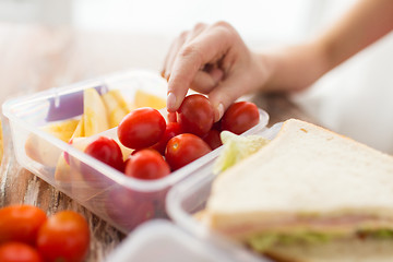 Image showing close up of woman with food in plastic container